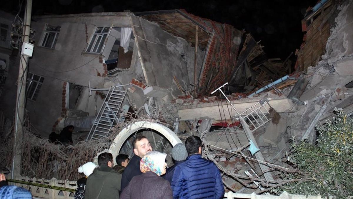 Un grupo de personas mira cómo ha quedado une dificio tras el terremoto.