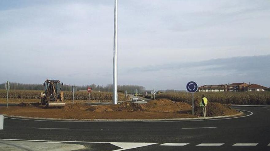 Una máquina extiende la tierra, a primera hora de ayer, en la rotonda de la carretera en Pumarejo.