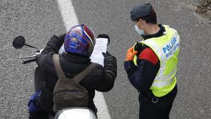 Un motorista muestra a un agente un justificante en un control de los Mossos en la Gran Via de Barcelona, junto a la Ciutat de la Justícia, el 7 de abril del año pasado.