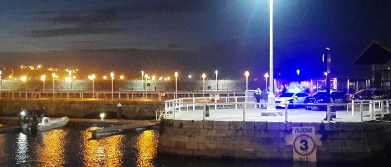 Agentes de la Policía Nacional y Portuaria, ayer, donde la Antigua Rula del puerto deportivo de Gijón, con la embarcación sustraída a la izquierda de la imagen.
