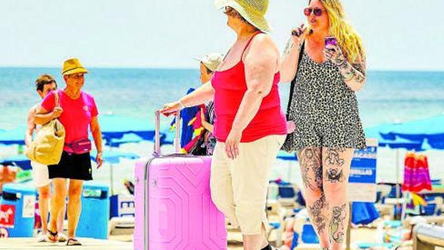Turistas británicos con maletas en Benidorm | David Revenga