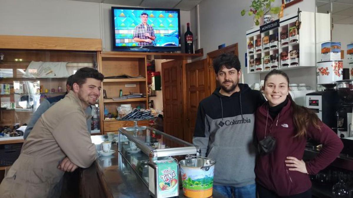 Alejandro Gallo y Yaiza Álvarez, tras la barra del bar de su negocio en Campiello (Tineo), con clientes. | S. Arias
