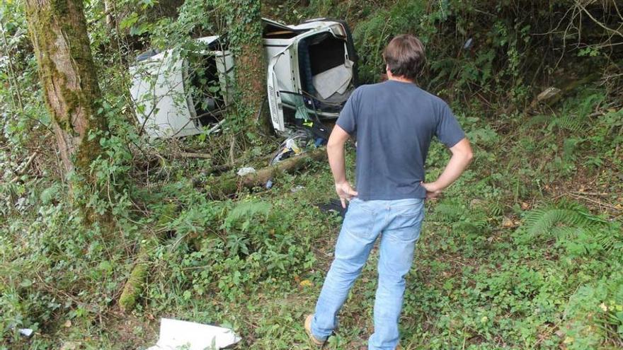 Un hombre observa el estado en el que quedó el coche tras el accidente.