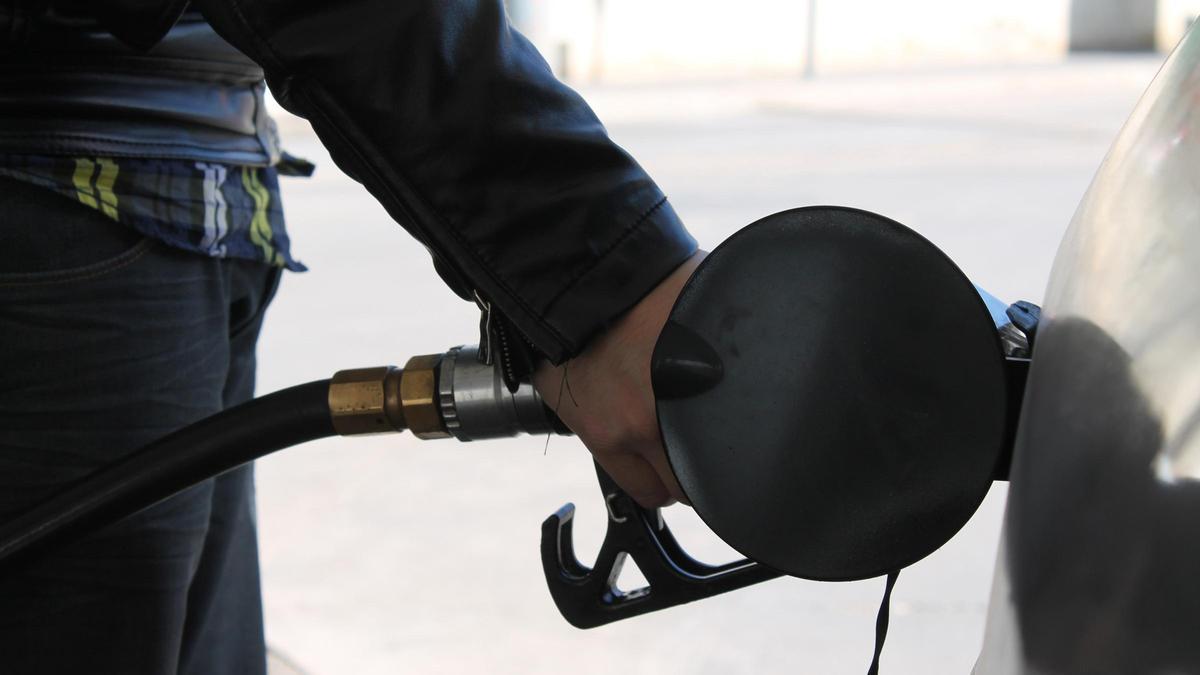 Una persona echa combustible a su vehículo en una estación de servicio.
