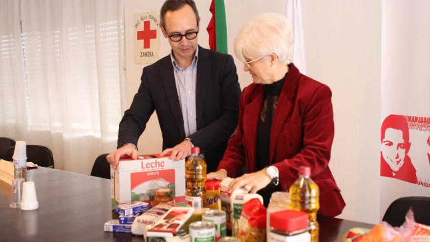 El director de la Fundación Alimerka y la presidenta de Cruz Roja muestran uno de los lotes de la campaña.