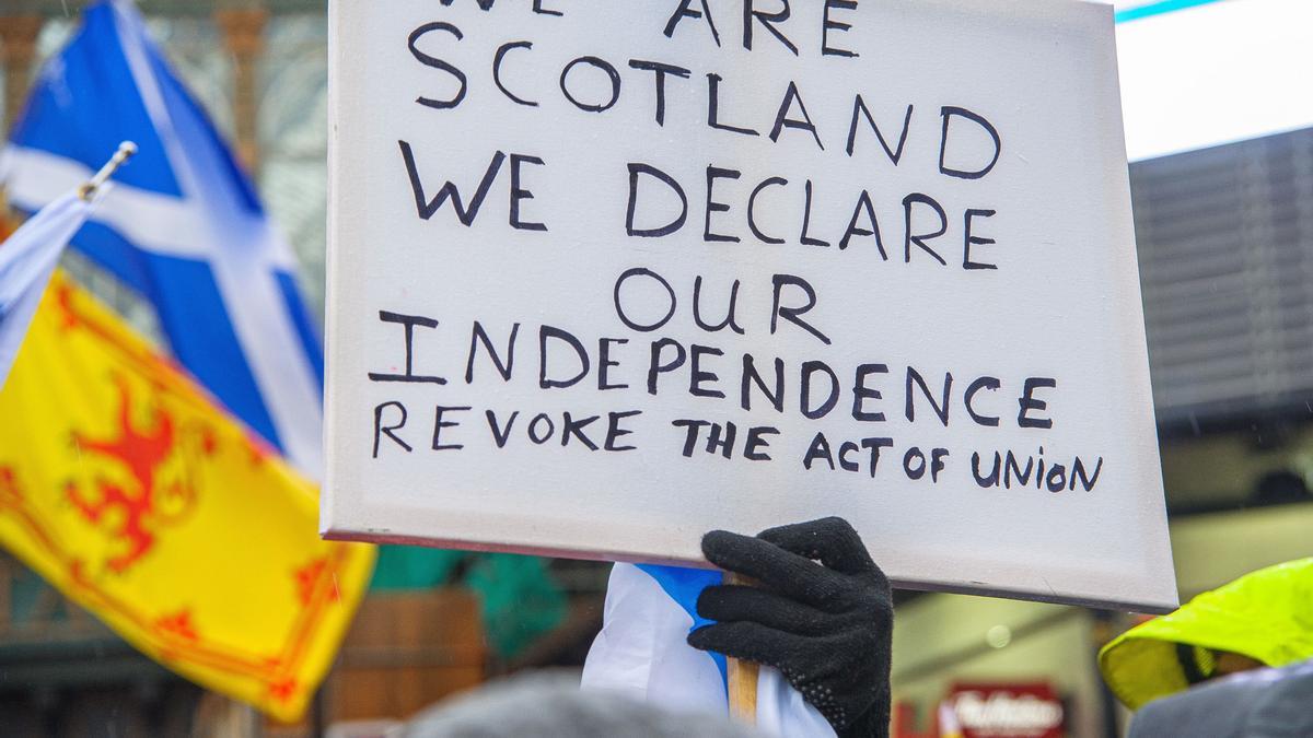 Un manifestante sostiene un cartel con proclamas independentistas en Escocia.