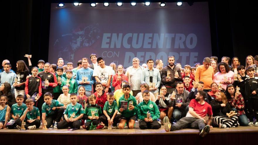 Foto de familia de los deportistas homenajeados en el escenario del teatro de El Entrego. | Tanais Menéndez