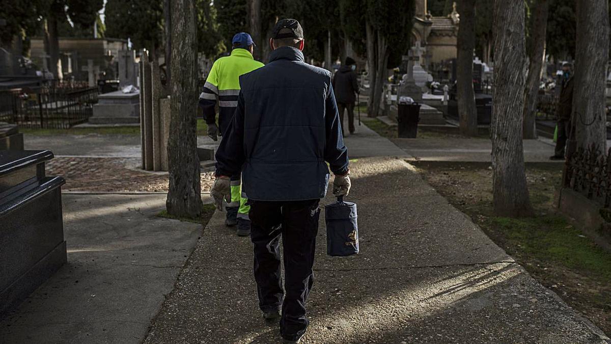 El encargado del camposanto lleva a la sepultura la urna con las cenizas de una anciana muerta por el virus | E. Fraile