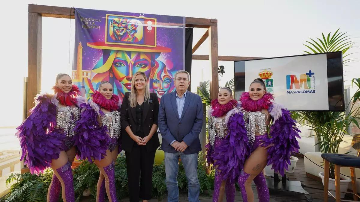 Yilenia Vega y Marco Aurelio Pérez, con unas figurantes, ante el cartel del Carnaval