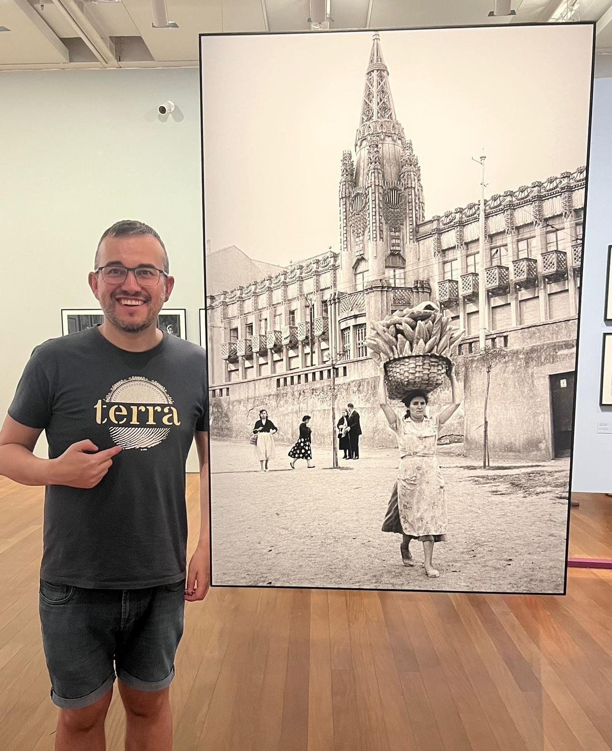 Carlos Callón posa con la fotografía de A Coruña en la exposición