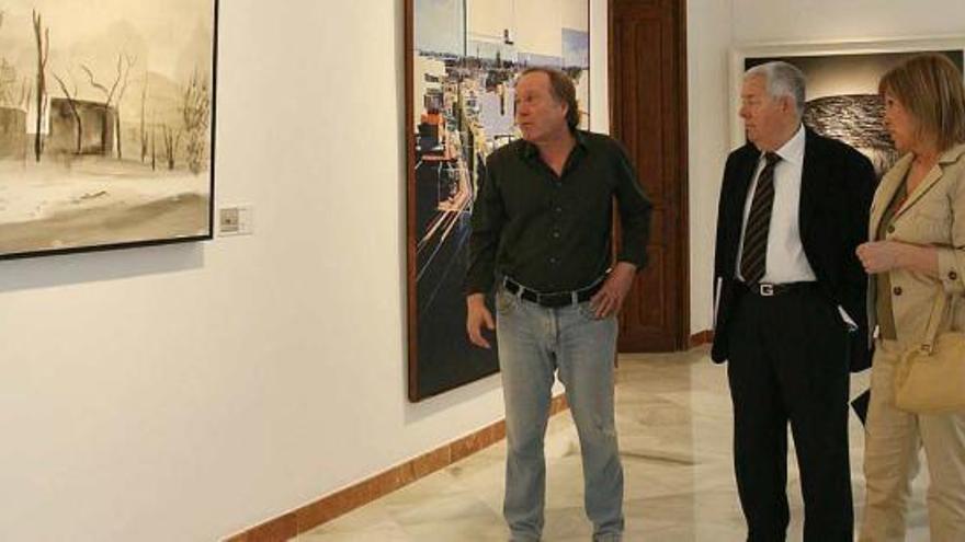 Pedro Romero, en el centro de la imagen, y Juana Mª Balsalobre observan una obra de la muestra.