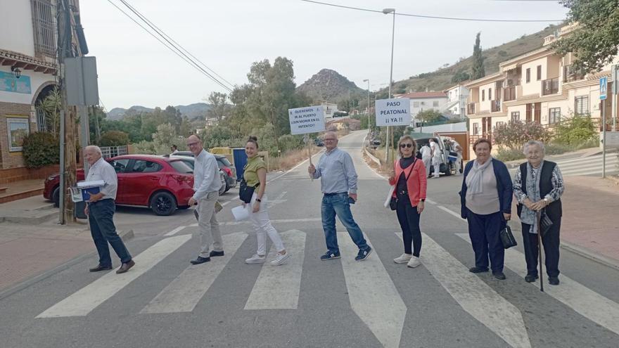 Miembros de la asociación de vecinos de la Junta de los Caminos, con carteles reivindicativos en mitad del barrio