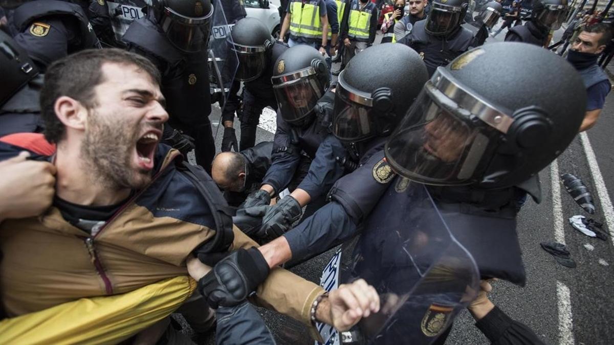 La policia nacional intenta desalojar a las personas concentradas en las puertas del colegio electoral Ramon Llull de Barcelona el 1-O.