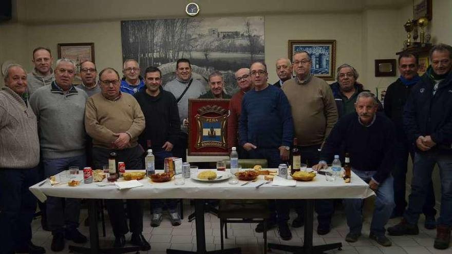 Peñistas de Borgoroso, en el local, mostrando su escudo.