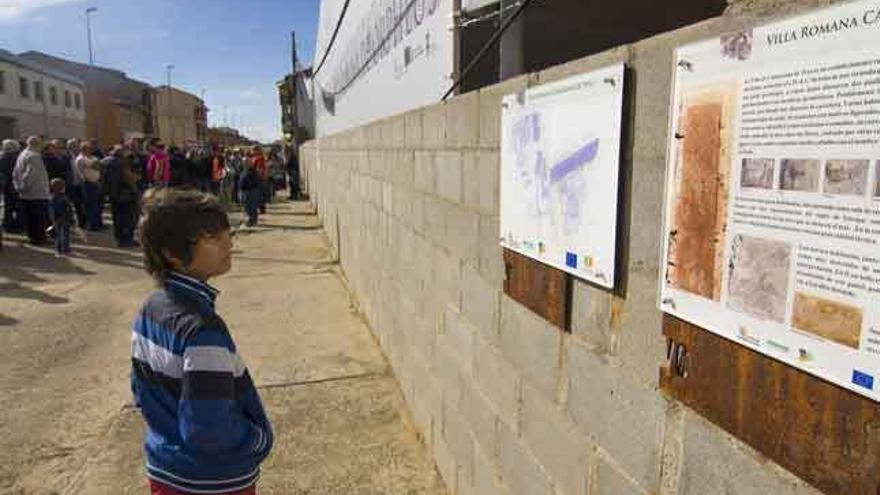 Un niño observa los carteles de la villa romana de Camarzana de Tera durante una reciente concentración. Foto