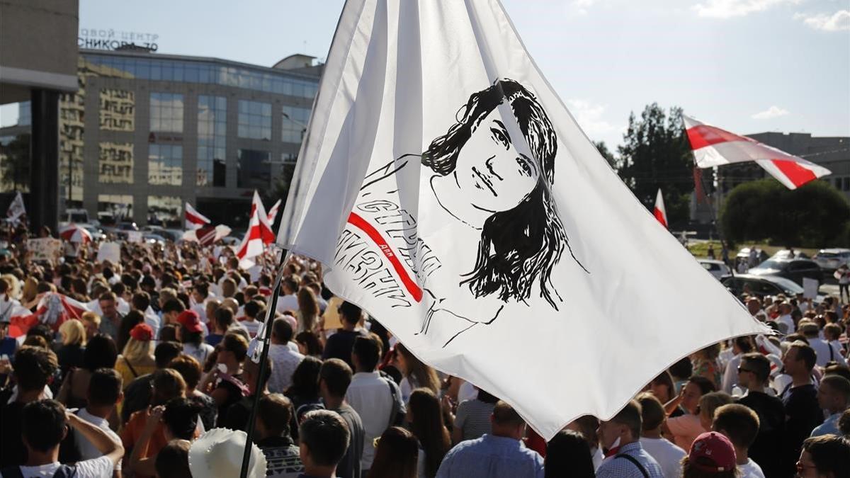 Manifestantes portan una bandera con un retrato de la líder opositora bielorrusa Svetlana Tikhonóvskaya, este lunes en Minsk.