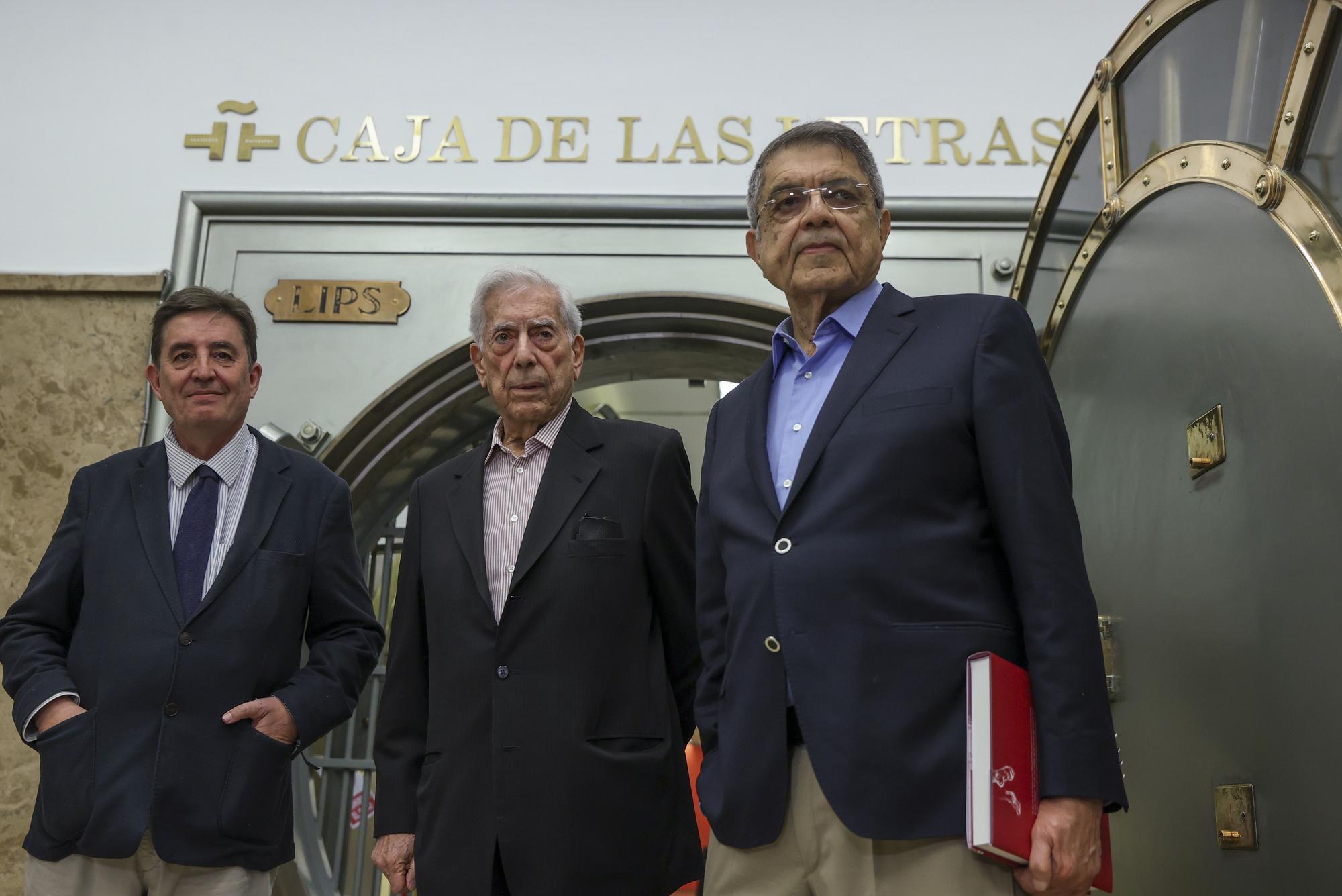 Vargas Llosa, flanqueado por Luis García Montero (izda.) y Sergio Ramírez, ante la caja fuerte del Instituto Cervantes, en Madrid.