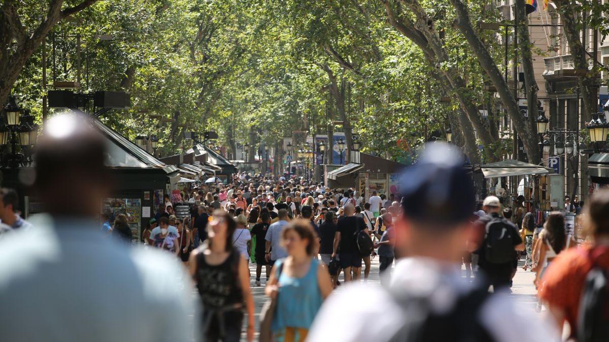 Decenas de personas pasean por la Rambla de Barcelona.