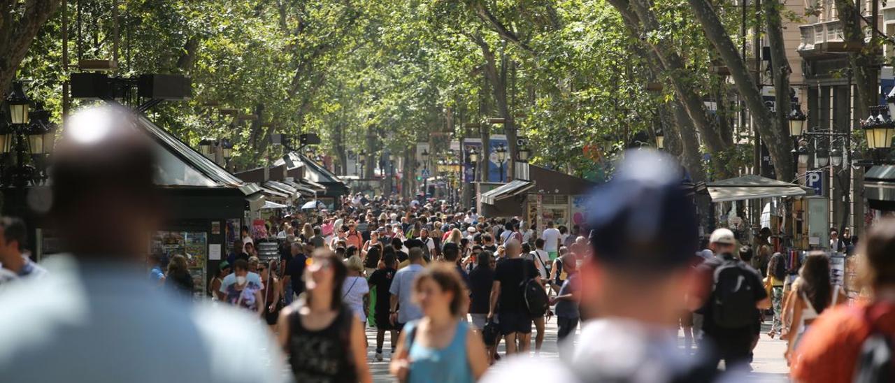 Decenas de personas pasean por la Rambla de Barcelona.