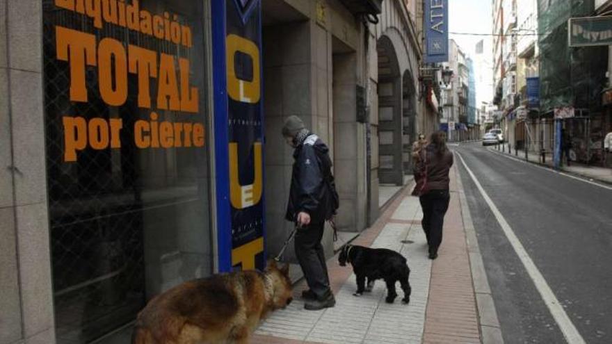 Establecimiento con el cartel de liquidación por cierre en una calle comercial de A Coruña. / fran martínez