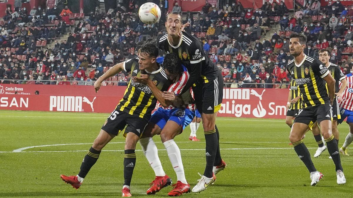 Petrovic y Chavarría tratan de despejar un balón ante la mirada de Adrián.