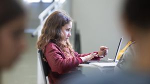 Una nena fa ús de lordinador portàtil a classe