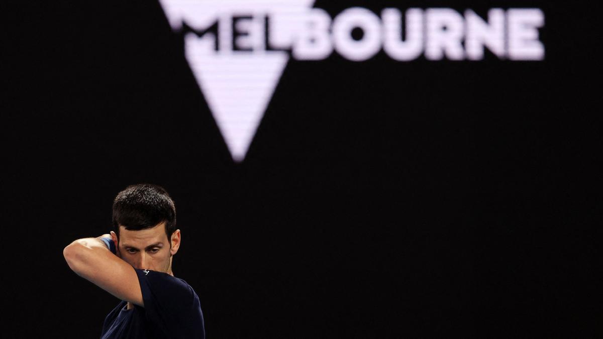 Novak Djokovic se limpia el sudor durante el entrenamiento de hoy, 14 de enero de 2022, antes del torneo de tenis Abierto de Australia en Melbourne.