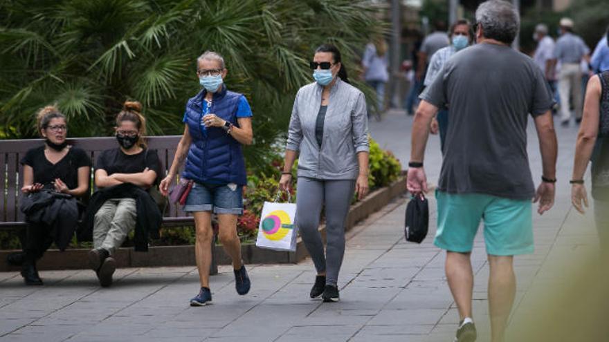 Personas con mascarilla transitan por Santa Cruz de Tenerife.