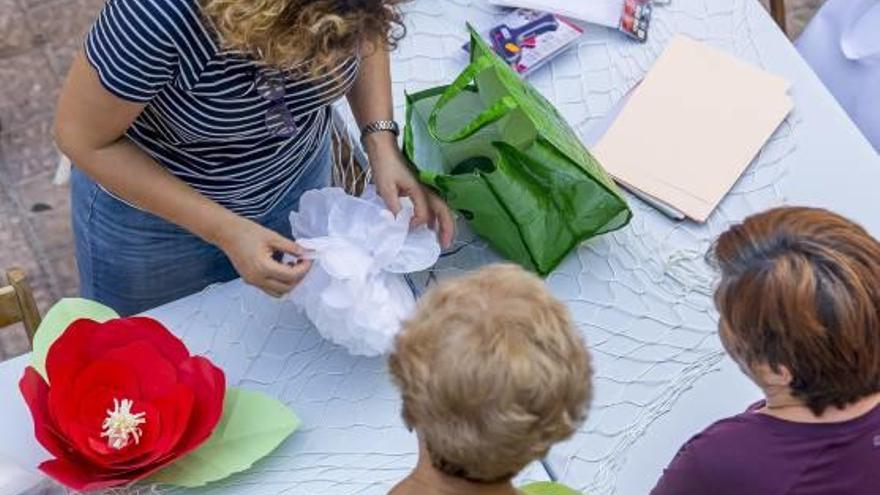 El grupo de mujeres que participan en el taller cada martes para confeccionar las redes. A la derecha, los árboles decorados con ganchillo del casco histórico.