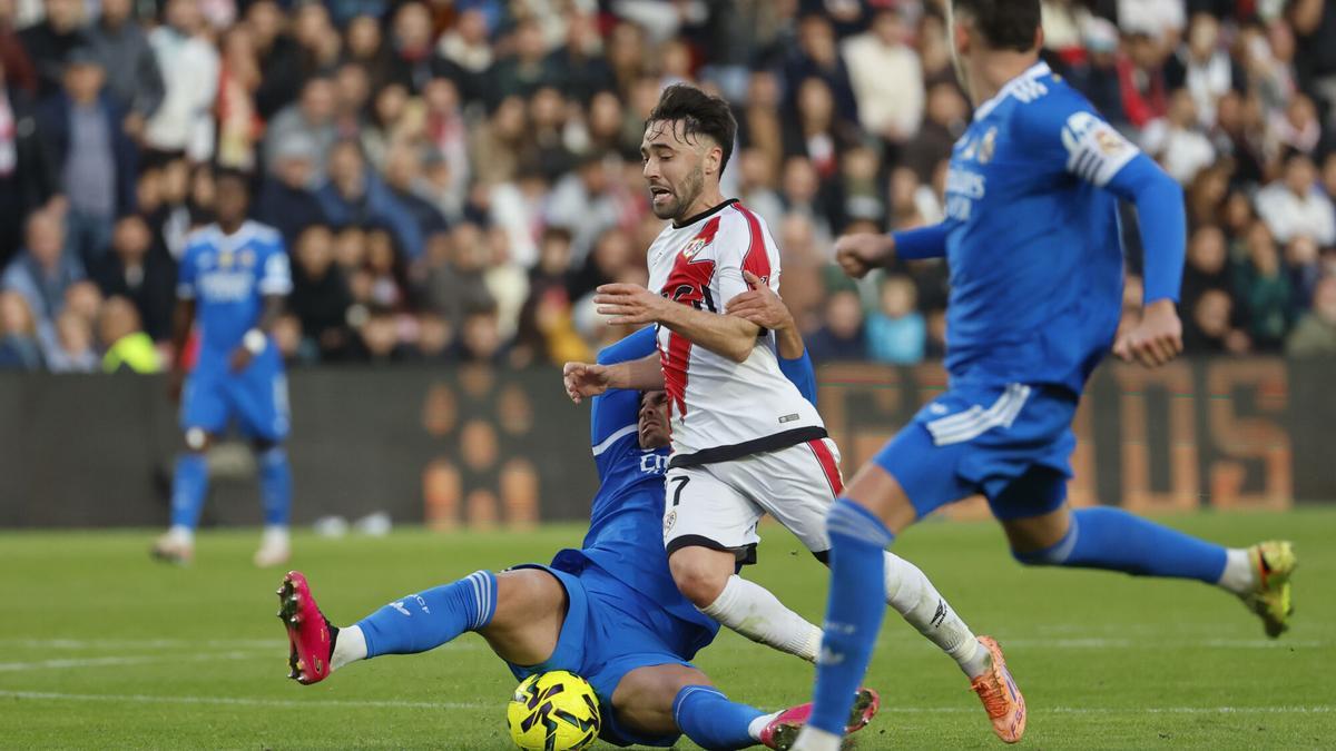 El centrocampista del Rayo Vallecano, Unai López, pelea un balón ante el defensa del Real Madrid Raúl Asencio.