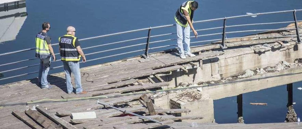 Efectivos de la Policía Científica, en el muelle colapsado a los pocos días del suceso. // C. Graña