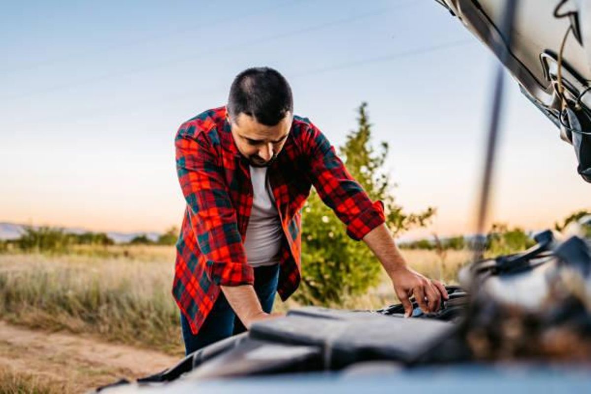Hombre revisando el motor de su coche