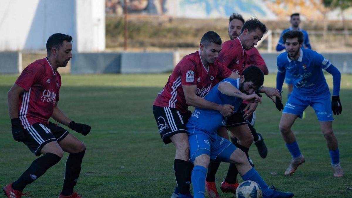 Un jugador del CD Fabero comete falta en su intento por recuperar el balón.