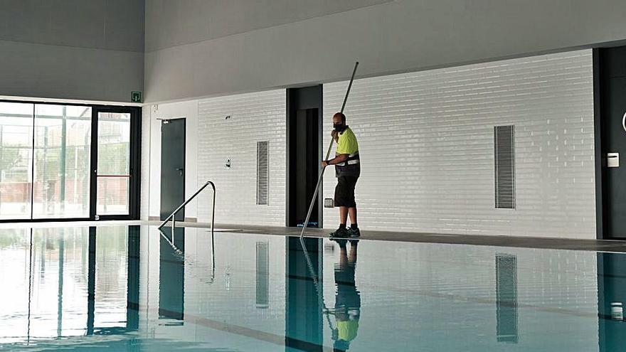 Un operari municipal netejant el vas de la piscina coberta, aquesta setmana