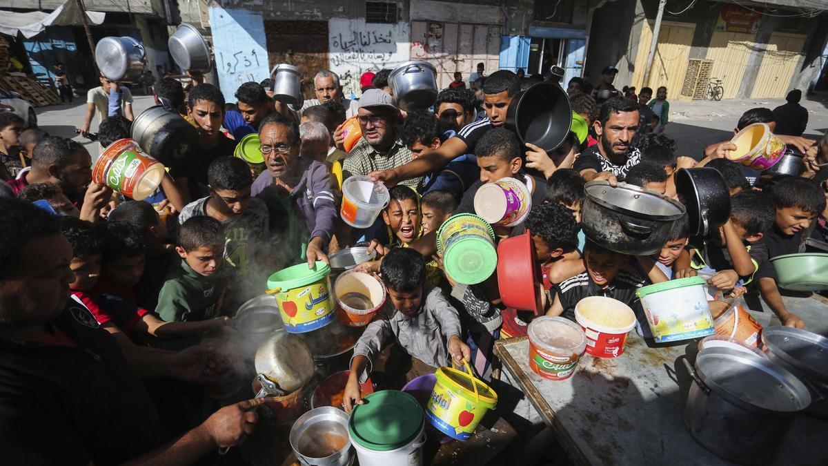 Palestinos se apiñan mientras esperan la distribución de alimentos en Rafah, en el sur de la Franja de Gaza.