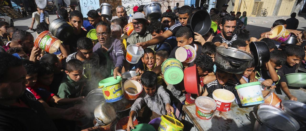 Palestinos se apiñan mientras esperan la distribución de alimentos en Rafah, en el sur de la Franja de Gaza.