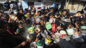 Palestinos se apiñan mientras esperan la distribución de alimentos en Rafah, en el sur de la Franja de Gaza.