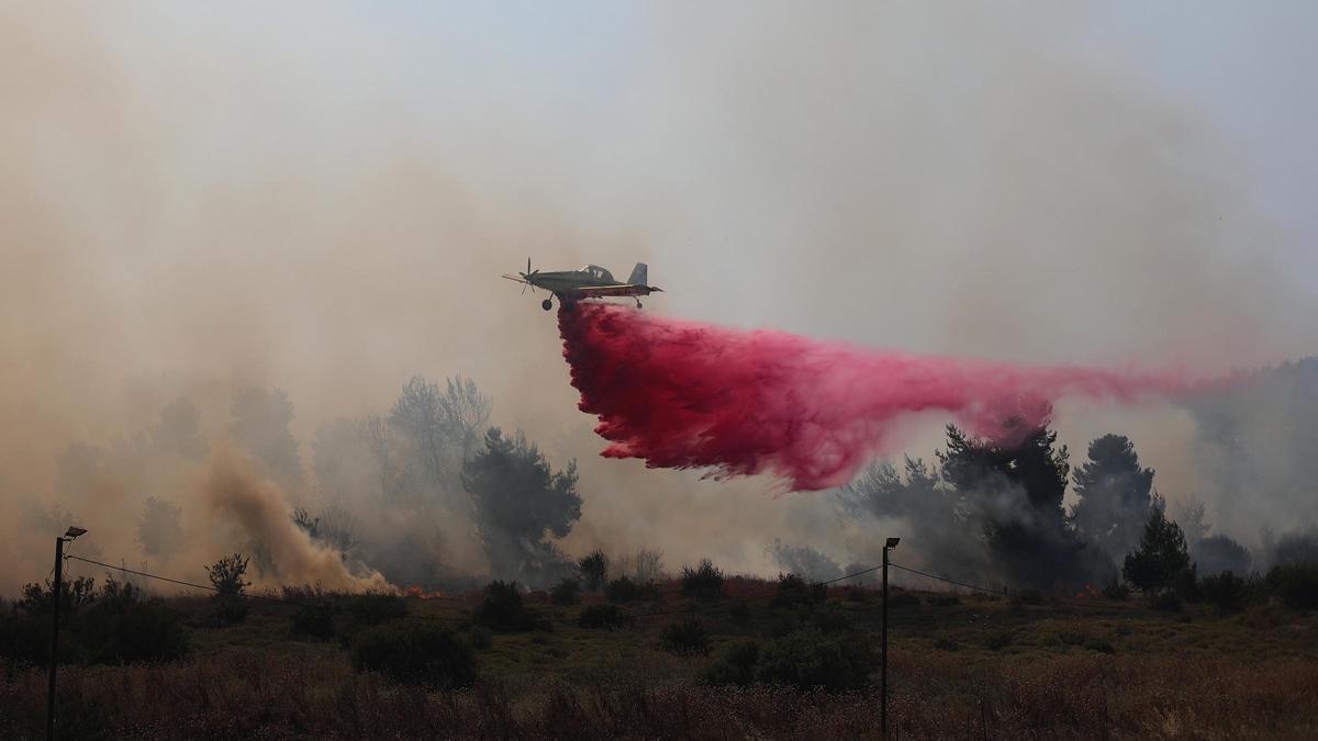 Una avioneta de los bomberos israelíes participa en la extinción de un incendio en el norte de Israel provocado por cohetes de Hizbulá, este miércoles.