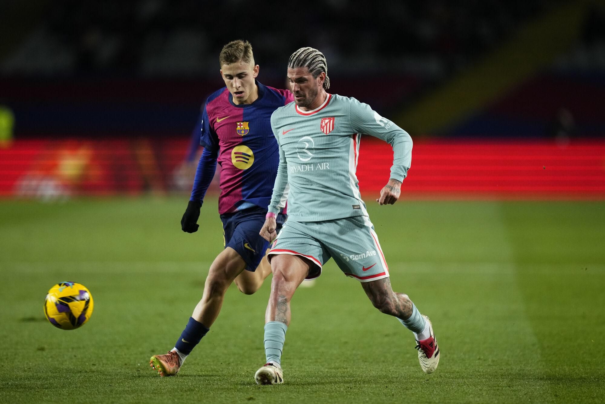 BARCELONA, 21/12/2024.- El centrocampista del FC Barcelona Fermín López (i) lucha con Rodrigo de Paul, del Atlético de Madrid, durante el partido de la jornada 18 de LaLiga entre el FC Barcelona y el Atlético de Madrid, este sábado en el estadio olímpico Lluis Companys. EFE/Siu Wu