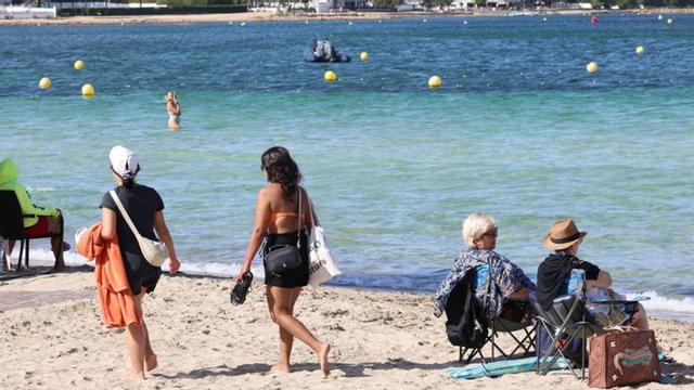 Turistas, este verano, en la playa de Cala de Bou. | JUAN A. RIERA