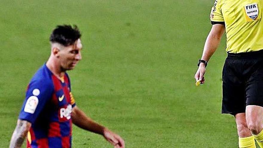 Hernández Hernández ensenyant la targeta groga a Messi.