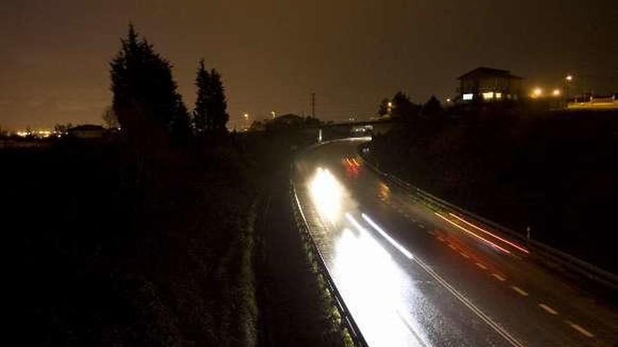 Coches circulando por la Variante en un tramo sin iluminar y con el pavimento mojado por la lluvia.