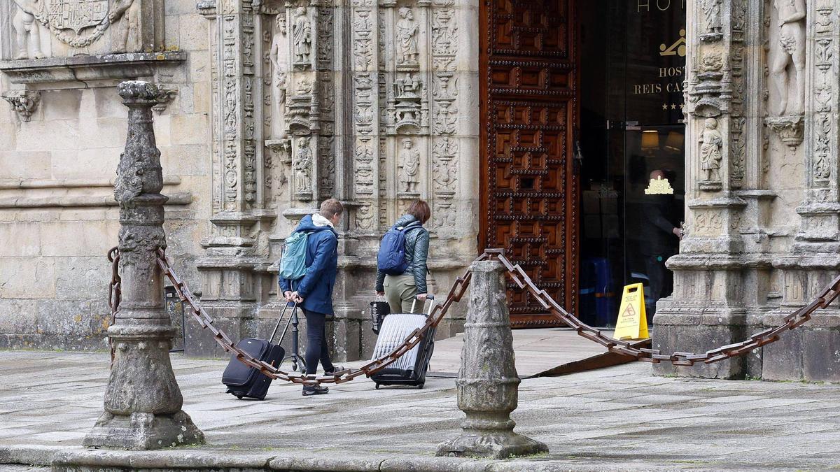 Dos turistas acceden con sus maletas al Hostal dos Reis Católicos