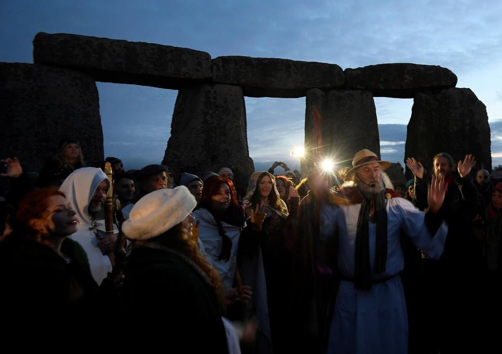 Miles de personas, varias de ellas disfrazadas de druidas, acudieron hoy al monumento de Stonehenge en Inglaterra para ver el amanecer con motivo del solsticio de invierno.