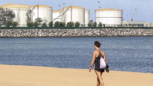 La playa del Arbeyal con insalaciones del puerto de El Musel al fondo. | PABLO SOLARES