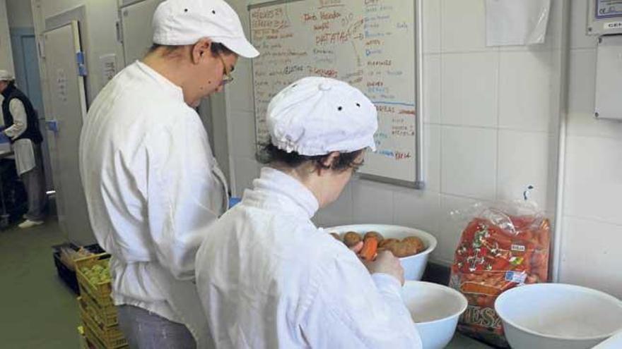 Dos jóvenes con discapacidad en un curso formativo de cocina.