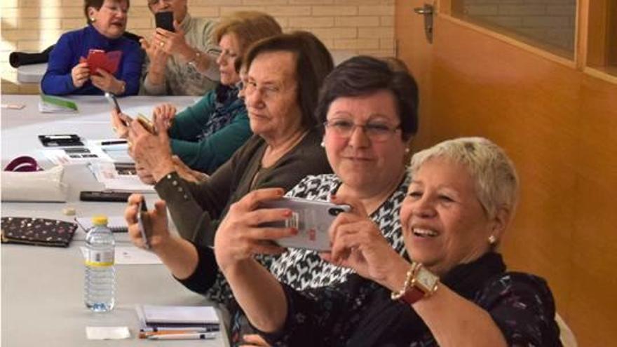 Personas mayores en el taller de uso de móviles de Grau-Port.