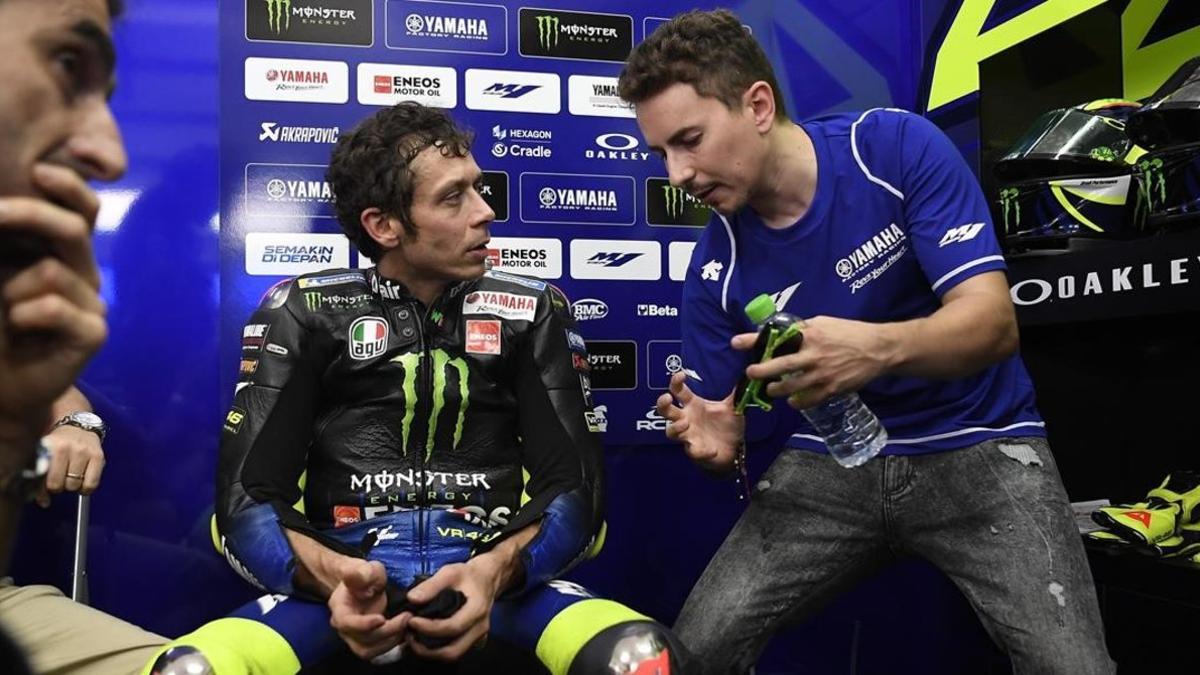 Valentino Rossi asiste, poco menos que atónito, a las explicaciones de diversas trayectorias que le cuenta Jorge Lorenzo en un descanso de los ensayos de ayer en Sepang.