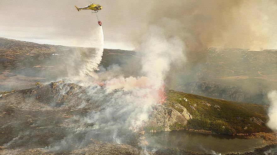 Un helicóptero realiza una descarga de agua durante el fuego en la sierra sanabresa.