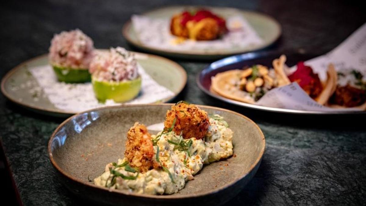 Varios platos del restaurante Salsa Street Food, con la ensaladilla rusa a base de mango, aguacate y langostino en primer plano.